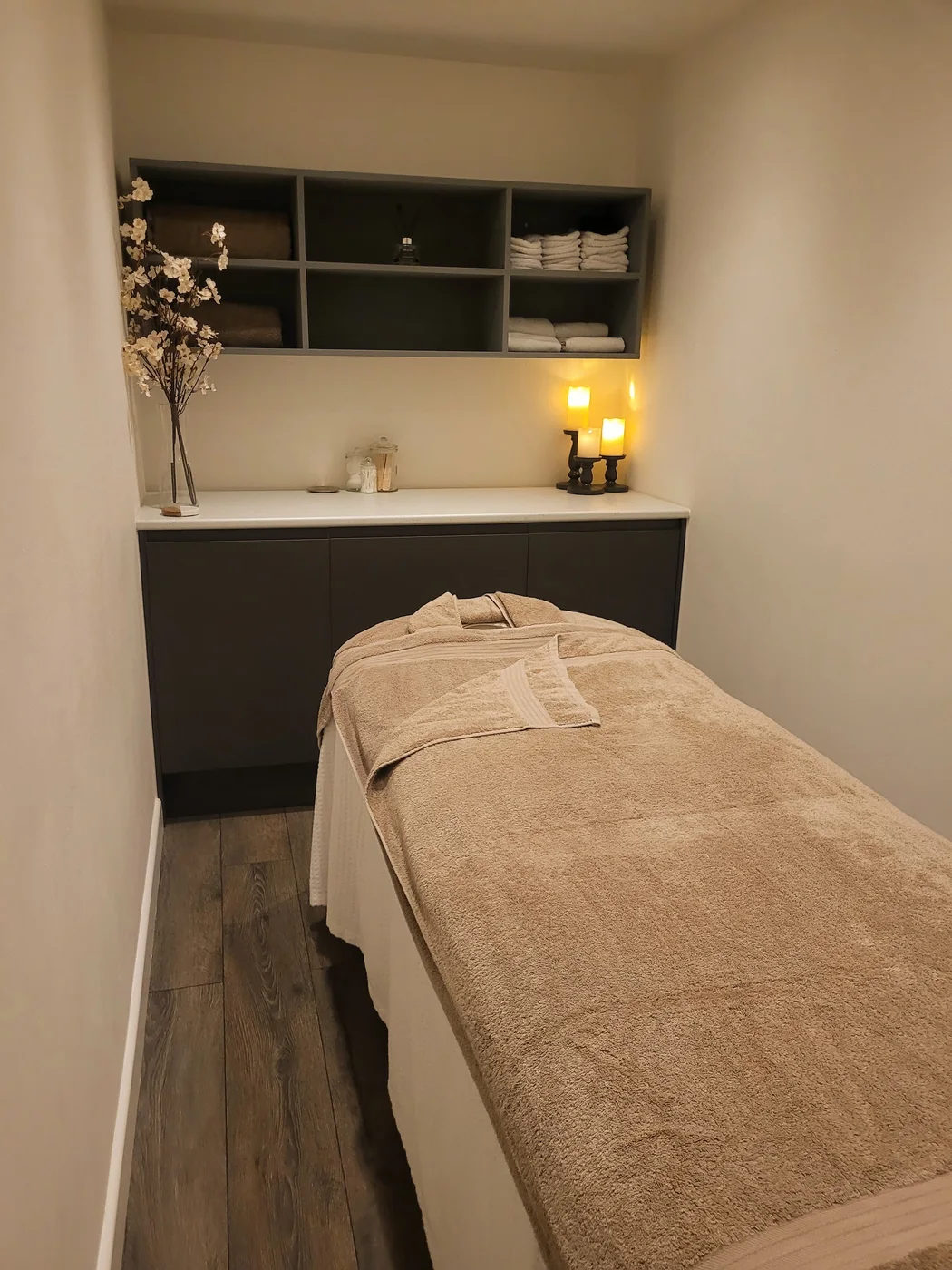 VGBeauty treatment room with a prepared couch, soft towels and candlelight